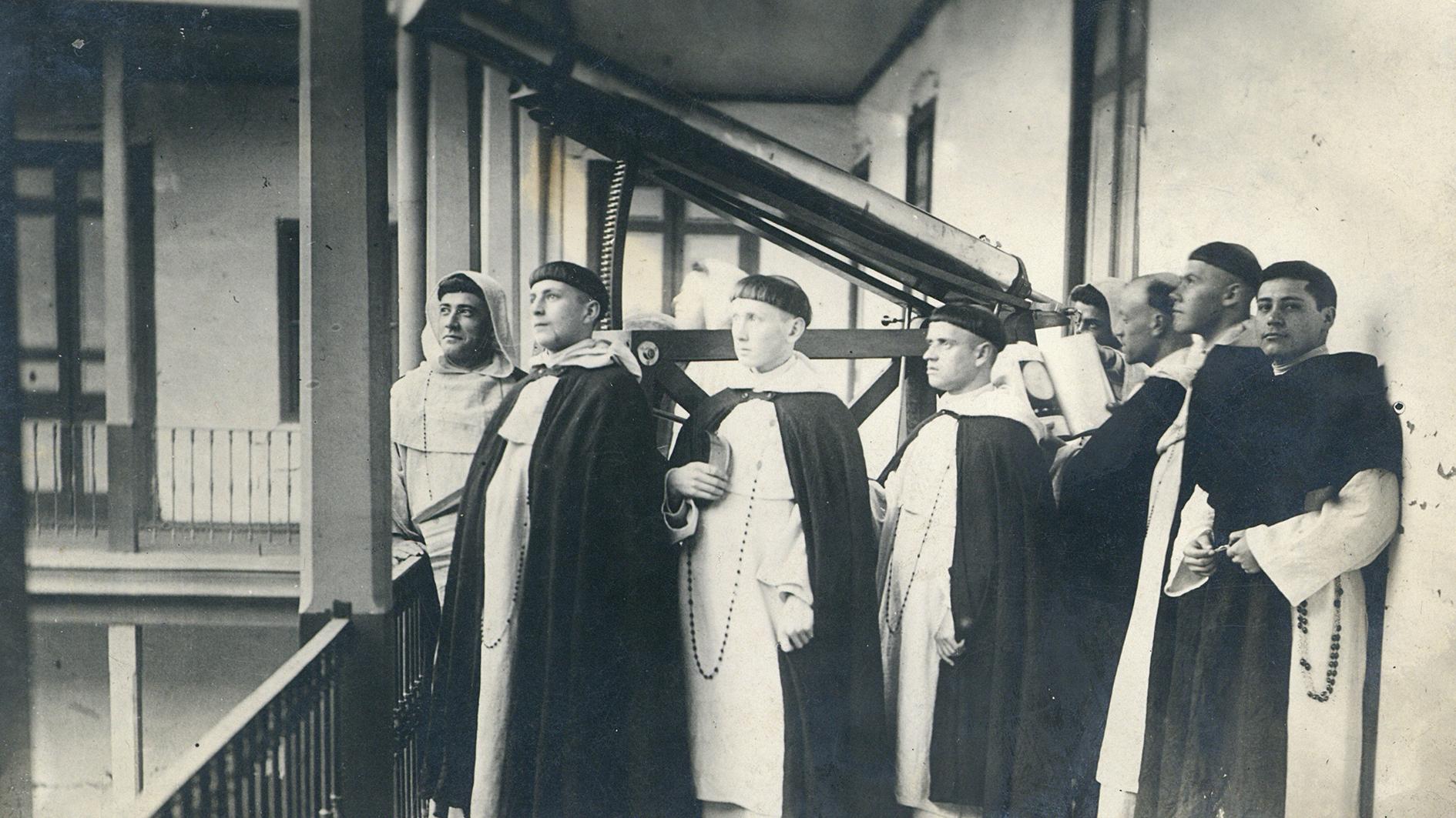 Fotografía que representa a un grupo de frailes dominicos con un telescopio