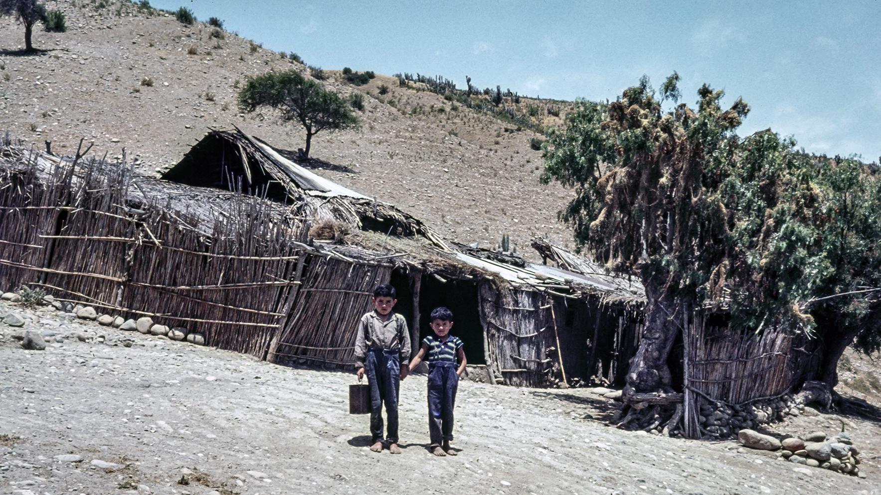 Niños posando frente a un rancho