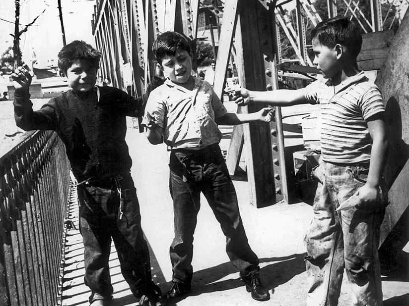 Tres niños en uno de los puentes del río Mapocho