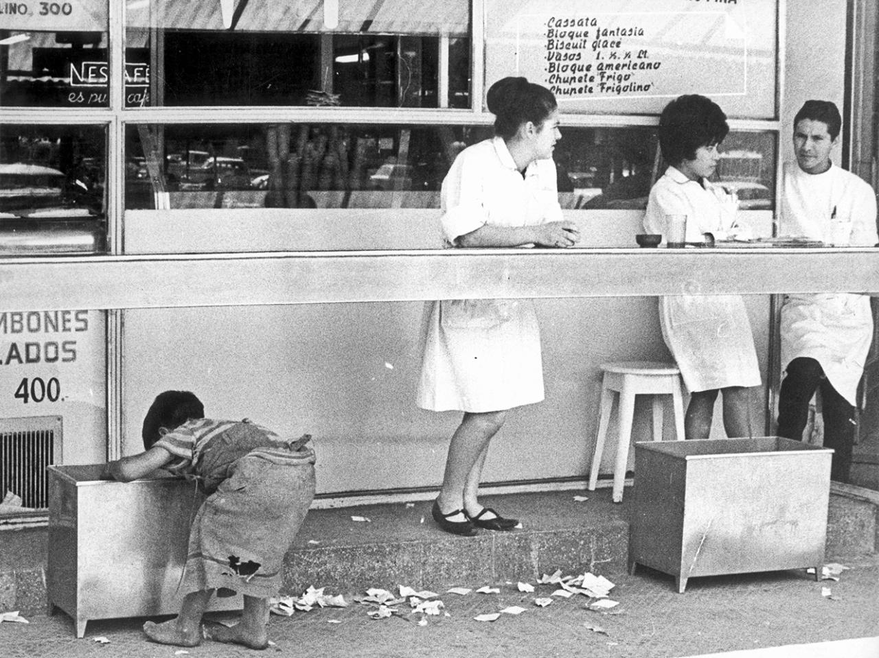 Niño recogiendo desperdicios en un negocio de comida