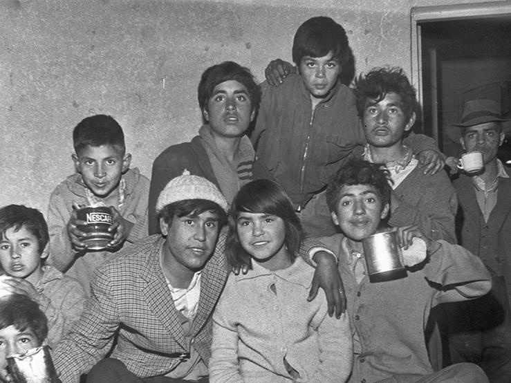 Retrato de un grupo de niños recibiendo alimentación en algún lugar de acogida