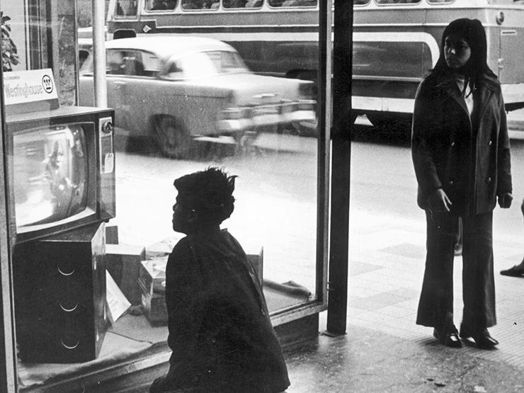 Niño mirando un televisor ubicado en vitrina de local comercial