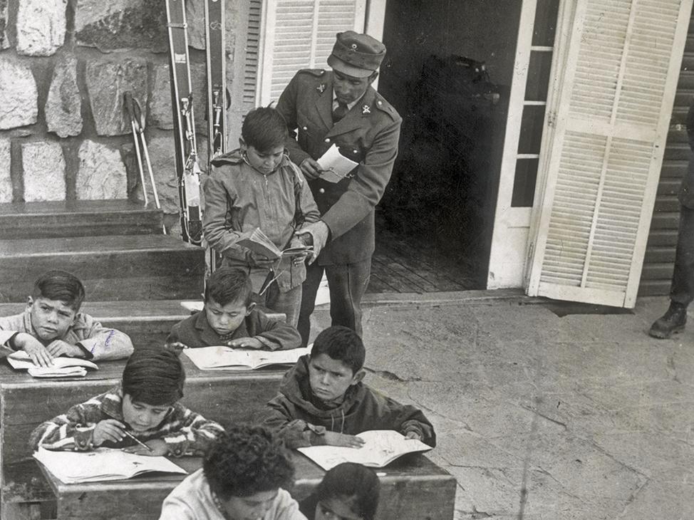 Carabinero ayuda a niños para que aprendan a leer