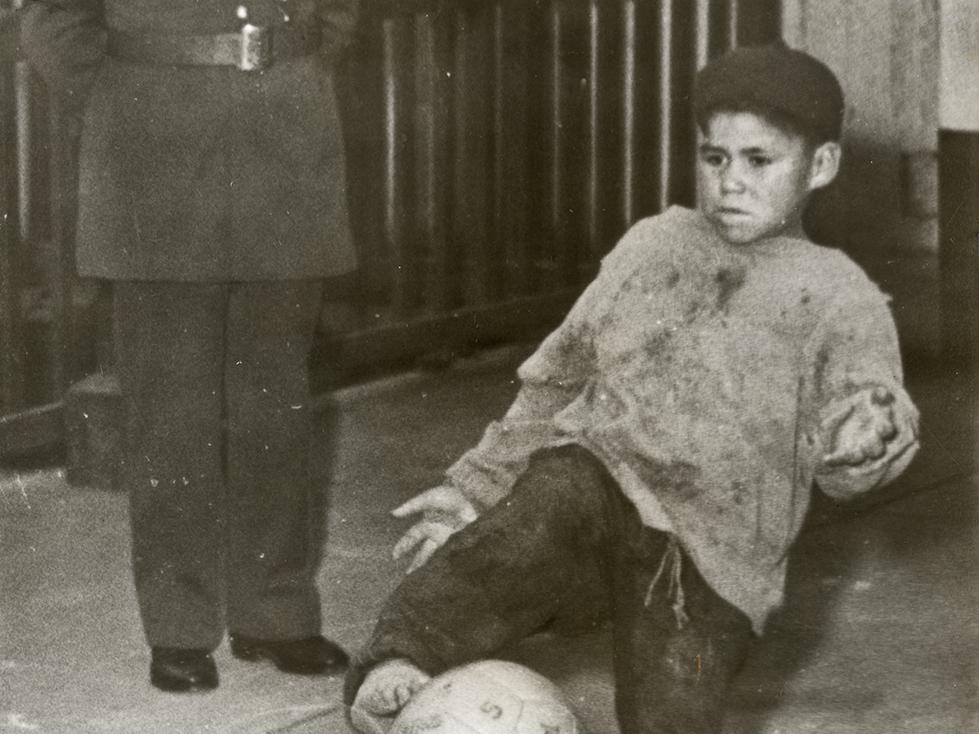 Carabinero observa a niño jugar a la pelota