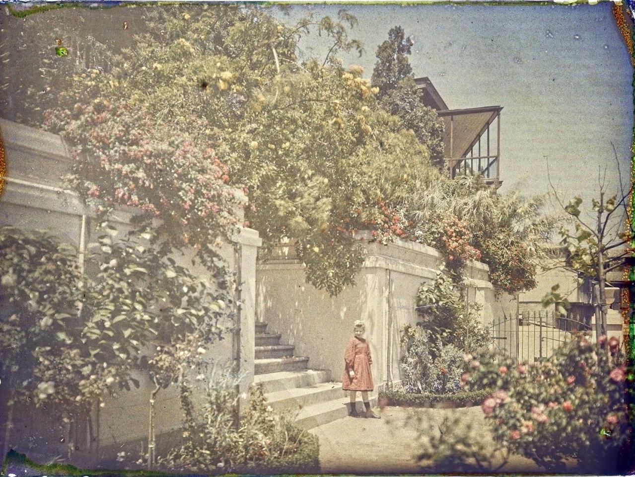 Niña en jardín y entrada de casona