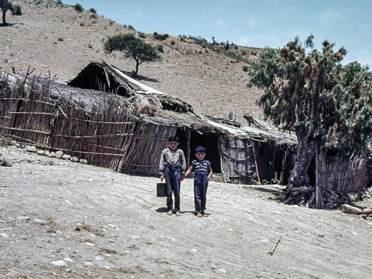 Niños posando frente a un rancho