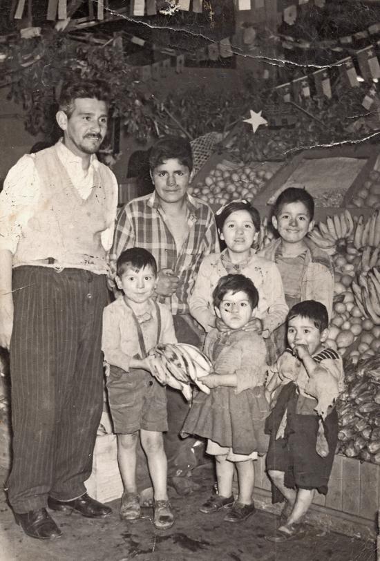 Niños junto a su padre en el negocio familiar, Temuco, 1960. 