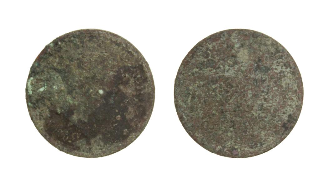 Pieza completa, de forma discoidal y de color marrón purpúreo, oscuro, con tintes verdes por oxidación