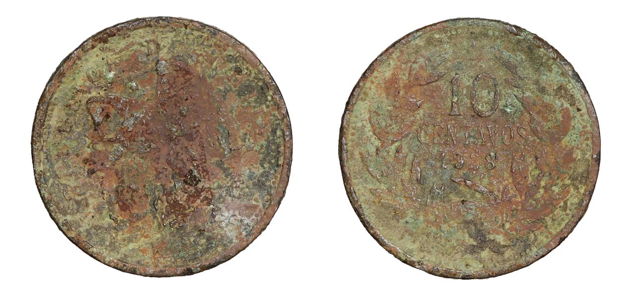 Pieza de forma circular, color marrón cubierta en parte por óxido de cobre