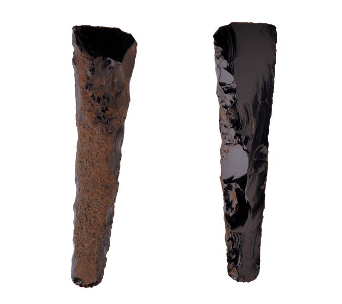 Cincel o Hoe de obsidiana con sección redondeada y filo recto, presencia de corteza