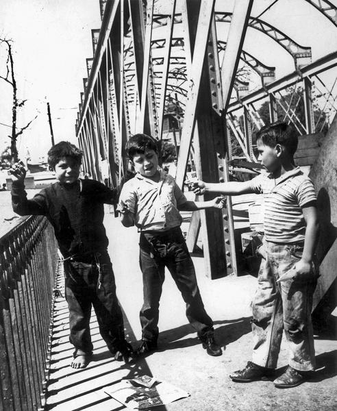 Tres niños en uno de los puentes del río Mapocho