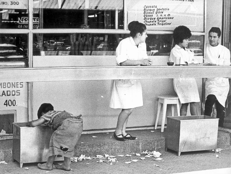 Niño recogiendo desperdicios en un negocio de comida