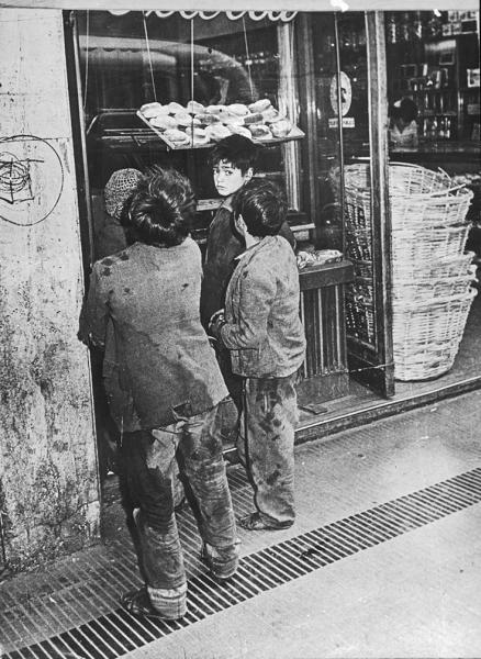 Grupo de niños frente vitrina de una panadería