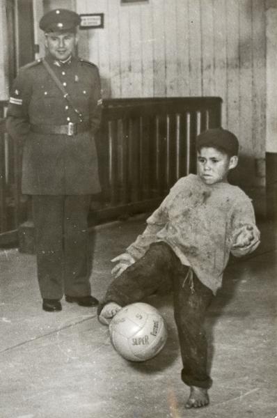 Carabinero observa a niño jugar a la pelota