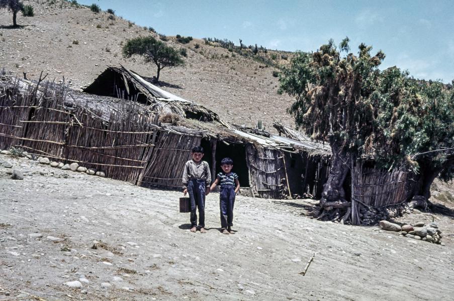 Niños posando frente a un rancho Niños posando frente a un rancho